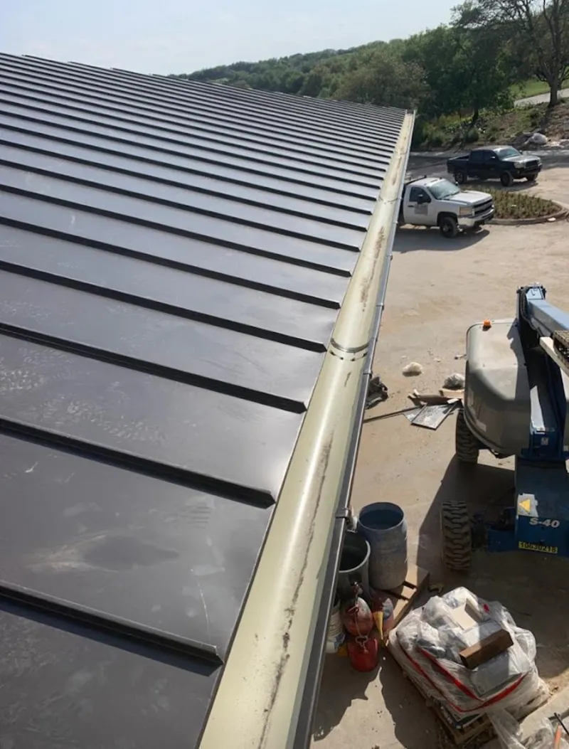 Standing seam panel and gutter detail on a metal roofing jobsite in Colby
